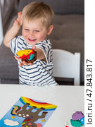 A little boy is playing with plasticine. Fine motor skills-developing games for children. The kid makes a horse. Useful games for child development. Стоковое фото, фотограф Photojuli / Фотобанк Лори