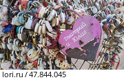 Huge rusty pink heart shaped castle with names written in Russian Dmitry and Julia. Tradition to hang padlocks on wedding day and throw away keys to it. Russia, Kostroma. Стоковое фото, фотограф Ирина / Фотобанк Лори