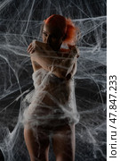 Red-haired woman caught in a delicate web trap, showcasing beauty and intrigue. Стоковое фото, фотограф Гурьянов Андрей / Фотобанк Лори