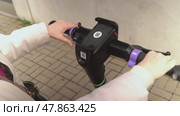 Russia, Sosnovy Bor, April 18, 2025 - Woman unlocking and locking an electric scooter with smartphone. Редакционное видео, видеограф Андрей Знаменский / Фотобанк Лори