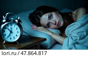 Contemplative serene portrait of a woman in bed with calm blue tones and classic alarm clock. Стоковое AI-изображение, AI-художник Андрей Бакусов / Фотобанк Лори
