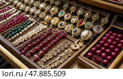 Ornate jewelry pieces are artistically arranged, showcasing a variety of bangles, earrings, and necklaces made with pearls and gemstones. Стоковое AI-изображение, AI-художник Данила Большаков / Фотобанк Лори
