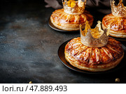 Galette des rois or king cake on a gray background with copy scape. Traditional cake at Epiphany. Twelfth Night after Christmas. Almond flaky pastry cake. Freshly baked homemade bread with a crown. Стоковое AI-изображение, AI-художник Марина Демидюк / Фотобанк Лори