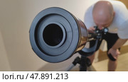 Man looks through telescope at night sky. Guy interested in science by studying stars. View from lens side. Home astronomy observatory. Close-up. Стоковое видео, видеограф Ирина / Фотобанк Лори