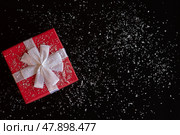 Red gift box with a white bow on a black background. Стоковое фото, фотограф Zakharova Natasha / Фотобанк Лори