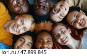 A diverse group of friends lying in a circle, heads together, smiling up at the camera, embodying friendship and inclusivity. Стоковое AI-изображение, AI-художник Данила Большаков / Фотобанк Лори
