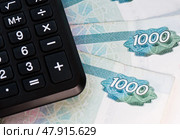Калькулятор и купюры номиналом 1000 рублей (крупный план) Стоковое фото, фотограф E. O. / Фотобанк Лори