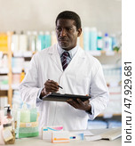 African man pharmacist makes restock. Стоковое фото, фотограф Яков Филимонов / Фотобанк Лори