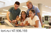 Group portrait of smiling positive engaged in research, working together in public library. Стоковое видео, видеограф Яков Филимонов / Фотобанк Лори