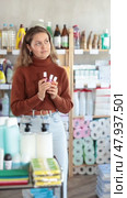 Young woman buyer chooses nail polish in household chemicals store. Стоковое видео, видеограф Яков Филимонов / Фотобанк Лори