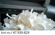 A Shredder Machine is Engaged in Shredding Confidential Documents, With Pieces of Paper Accumulating in a Heap. Стоковое AI-изображение, AI-художник Sergey Grishin / Фотобанк Лори