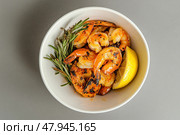 Shrimps, lemon and rosemary in a plate. Seafood. Gourmet king prawn in the bowl. A bowl of fresh shrimp served. Garnish. Prawns. Jumbo Shrimp Scampi in Butter and Olive Oil. Preparation. Стоковое AI-изображение, AI-художник Марина Демидюк / Фотобанк Лори