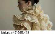 Charming woman standing in a dress adorned with ruffles, creating a textured and voluminous look. Стоковое AI-изображение, AI-художник Данила Большаков / Фотобанк Лори