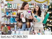 Two women choose detergents and sprays at great Christmas discounts. Стоковое фото, фотограф Яков Филимонов / Фотобанк Лори