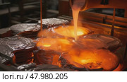 Close-up of molten metal being poured into molds in a foundry, showcasing the intense heat and craftsmanship of metalworking. Стоковое AI-видео, аниматор Михаил Строгалев / Фотобанк Лори