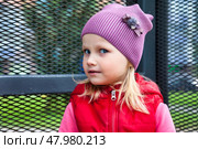 Charming Five Year Old Girl With a Playful Expression Enjoying the Outdoors in a Knitted Hat. Стоковое фото, фотограф Aleksandr Golubev / Фотобанк Лори
