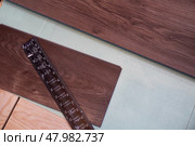 Top view of the laying of laminate boards on the underlying floor layer. Home renovation concept. Стоковое AI-изображение, AI-художник Виктория Тельминова / Фотобанк Лори