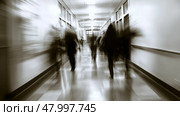 A somewhat blurry hospital corridor filled with numerous people walking about on their various errands and duties. Стоковое AI-изображение, AI-художник Anastasy Yarmolovich / Фотобанк Лори