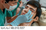 Students enhance their skills by practicing suturing on a realistic mannequin during a medical training session. Стоковое AI-изображение, AI-художник Данила Большаков / Фотобанк Лори