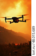 Drone is flying over a forest with a fire in the background. Стоковое AI-изображение, AI-художник Sergey Grishin / Фотобанк Лори
