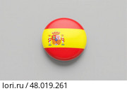 Round badge featuring Spanish flag with red yellow stripes and national coat of arms isolated on gray background for travel culture education. 3d rendering. Стоковое фото, фотограф Павел Муравьев / Фотобанк Лори