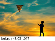 Мальчик запускает воздушного змея на закате в поле. Стоковое AI-изображение, AI-художник Александр Жуков / Фотобанк Лори
