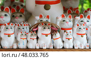 Tokyo, Japan - Sep 30 2024, A close-up view of many multi-sized white beckoning cat figure of Maneki neko with red ears and noses displayed at Gotokuji Temple, without people, at daytime, Tokyo, Japan. Стоковое фото, фотограф Сергей Богомяко / Фотобанк Лори