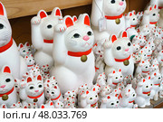 Tokyo, Japan - Sep 30 2024, A close-up view of many multi-sized white beckoning cat figure of Maneki neko with red ears and noses displayed at Gotokuji Temple, without people, at daytime, Tokyo, Japan. Стоковое фото, фотограф Сергей Богомяко / Фотобанк Лори