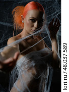 Red-haired woman ensnared in a delicate net trap amidst a dark background. Стоковое фото, фотограф Гурьянов Андрей / Фотобанк Лори