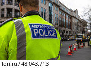 Metropolitan Police officer wearing high visibility jacket patrolling London street. Стоковое фото, фотограф Zydrius Tartenis / Фотобанк Лори