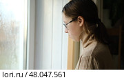 Teen girl is cleaning window in apartment. Teenager female cleaner using a squeegee to wash a window. Girl wiping, washing glasses with with spray bottle, rag and vacoom. Everyday chores. Purification. Стоковое видео, видеограф Марина Демидюк / Фотобанк Лори