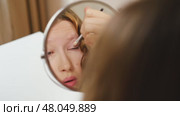 Teen Girl putting on makeup looking at mirror. Beautiful Teenager caring her face. 14 years old female applied cosmetics. Natural beauty concept. Skin care, make-up. Daily make up. Beautiful Teenage. Стоковое видео, видеограф Марина Демидюк / Фотобанк Лори