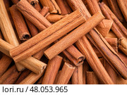 Cinnamon background. Pile of cinnamons stick top view. Cinnamomum cassia close up. Spice for the Holidays. Assortment of spices. Cinnamon bark is a spice used for sweet and savory dish. Стоковое AI-изображение, AI-художник Марина Демидюк / Фотобанк Лори