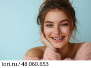Beautiful young woman with orthodontic brackets on color background. Красивая молодая женщина с ортодонтическими скобками на цветном фоне. Стоковое AI-изображение, AI-художник Katsiaryna Repich / Фотобанк Лори