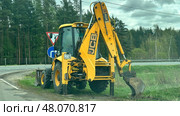 Экскаватор-погрузчик JCB на обочине дороги. Редакционное фото, фотограф Антон Моргунов / Фотобанк Лори