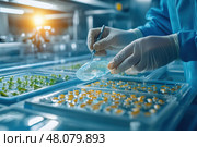 An aquaculture worker closely examines tiny fish fry in a specialized incubation tray. The image captures the meticulous process of fish breeding and the intricate details of hatchery management. Стоковое AI-изображение, AI-художник Nart / Фотобанк Лори