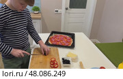 A fun-loving boy learns to make pizza, experimenting with toppings and enjoying every step of the process. Cooking magic. Стоковое видео, видеограф Ирина Старикова / Фотобанк Лори