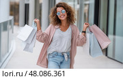 Stylish Young Woman Excited with Shopping Bags, Store Discounts and Promotions. Модная молодая счастливая девушка  с покупками, сделанными во время шопинга. Скидки и акции в магазинах. Стоковое AI-изображение, AI-художник Katsiaryna Repich / Фотобанк Лори