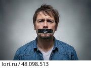 Man with his mouth taped shut looks sadly at the camera. Стоковое AI-изображение, AI-художник Дмитрий Киселёв / Фотобанк Лори