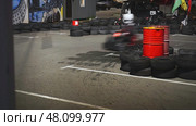 The Thrilling and Exciting Scene of Indoor GoKart Racing Offers an Unforgettable Experience. Стоковое фото, фотограф David Kashakhi / Фотобанк Лори