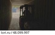A forklift transports goods through a wide warehouse passageway, enhancing efficiency. Стоковое фото, фотограф David Kashakhi / Фотобанк Лори