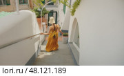 Woman walking down narrow stairs between buildings and gestures follow me in Italian city. Стоковое видео, видеограф Igor Tichonow / Фотобанк Лори