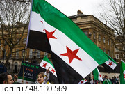 Freedom for Syria activists waving Syrian independence flag. London, UK, 16 March 2024. Редакционное фото, фотограф Zydrius Tartenis / Фотобанк Лори