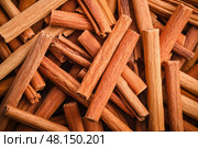 Cinnamon background. Pile of cinnamons stick top view. Cinnamomum cassia close up. Spice for the Holidays. Assortment of spices. Cinnamon bark is a spice used for sweet and savory dish. Стоковое AI-изображение, AI-художник Марина Демидюк / Фотобанк Лори