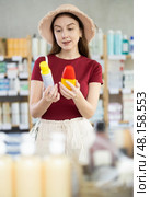 Young woman choosing repellent in chemist's shop. Стоковое фото, фотограф Яков Филимонов / Фотобанк Лори