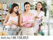 Interested mother and daughter clients looking box of paracetamol antipyretic pills, young woman pharmacist helping choosing box and making decisions in drug store. Стоковое фото, фотограф Яков Филимонов / Фотобанк Лори