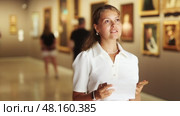 Woman with sheet piece of paper in hands view pictures and icons in museum hall. Стоковое видео, видеограф Яков Филимонов / Фотобанк Лори