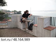 Photographer sitting and enjoying view of lisbon cityscape and tagus river. Стоковое фото, фотограф Константин Шишкин / Фотобанк Лори
