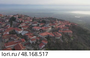 Scenic spring view from drone of Signagi township with narrow winding streets situated on hill in foothills of Gombori Range, Georgia. Стоковое видео, видеограф Яков Филимонов / Фотобанк Лори
