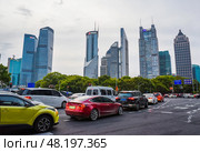 Shanghai, China – 1 April 2025: Traffic at busy intersection in Pudong with modern skyscrapers including HSBC and China Merchants Bank towers. Редакционное фото, фотограф Татьяна Терехина / Фотобанк Лори